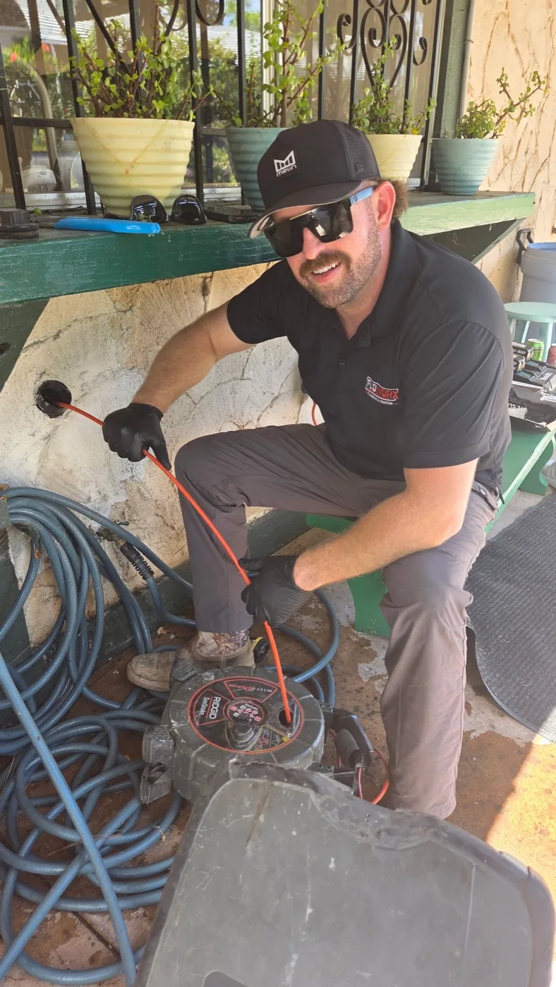 Floworx plumber clearing a drain line with cable equipment